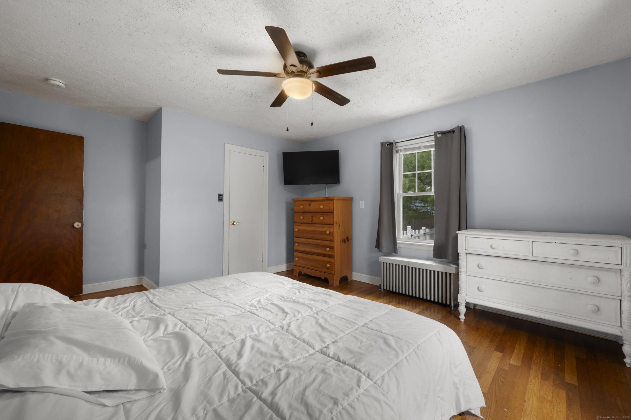 Alternate view of bedroom at 140 Woodhouse Ave showing natural wood doors and bright windows.