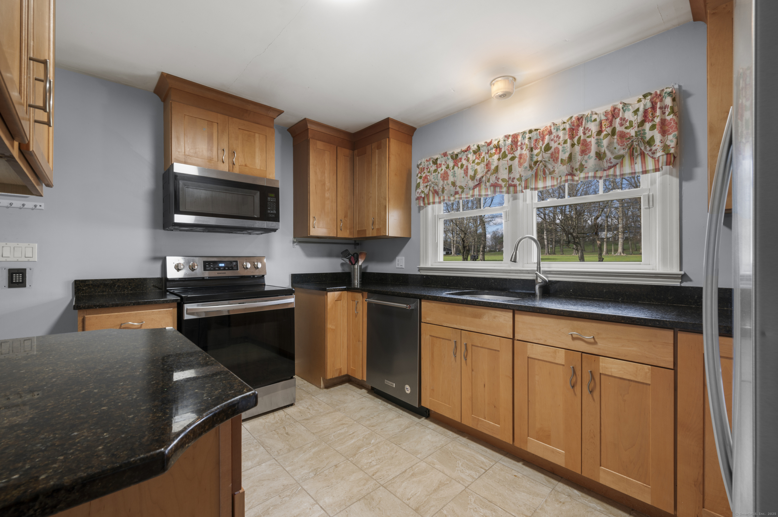 Kitchen at 140 Woodhouse Ave featuring maple cabinetry, granite countertops, and stainless steel appliances.