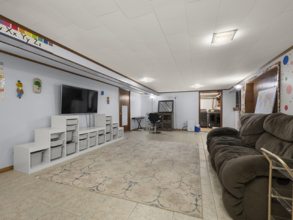 Lower level media room at 140 Woodhouse Ave with storage cubbies and alphabet wall decor.