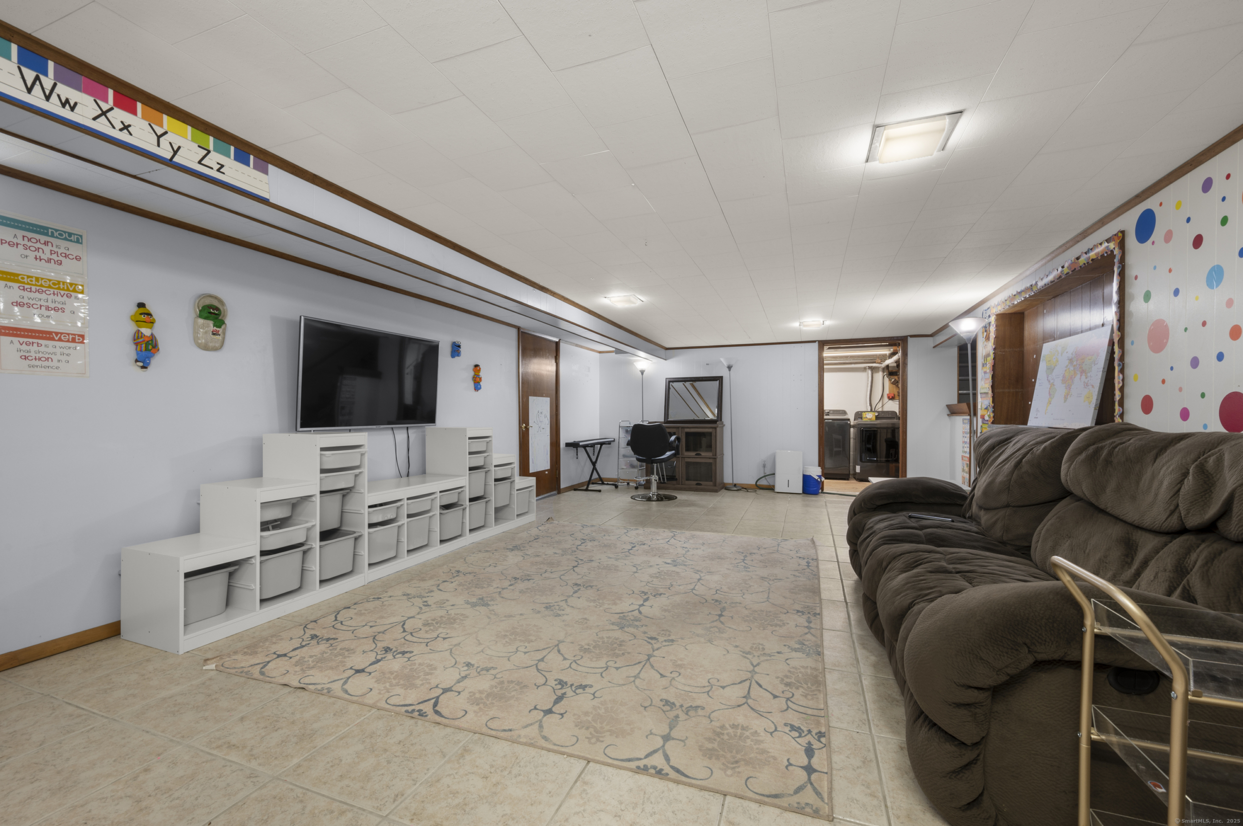 Lower level media room at 140 Woodhouse Ave with storage cubbies and alphabet wall decor.