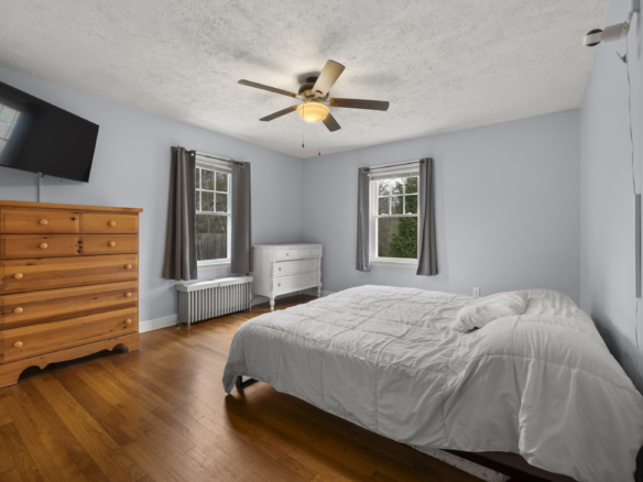 Primary bedroom at 140 Woodhouse Ave with light blue walls, hardwood floors, and natural wood trim.