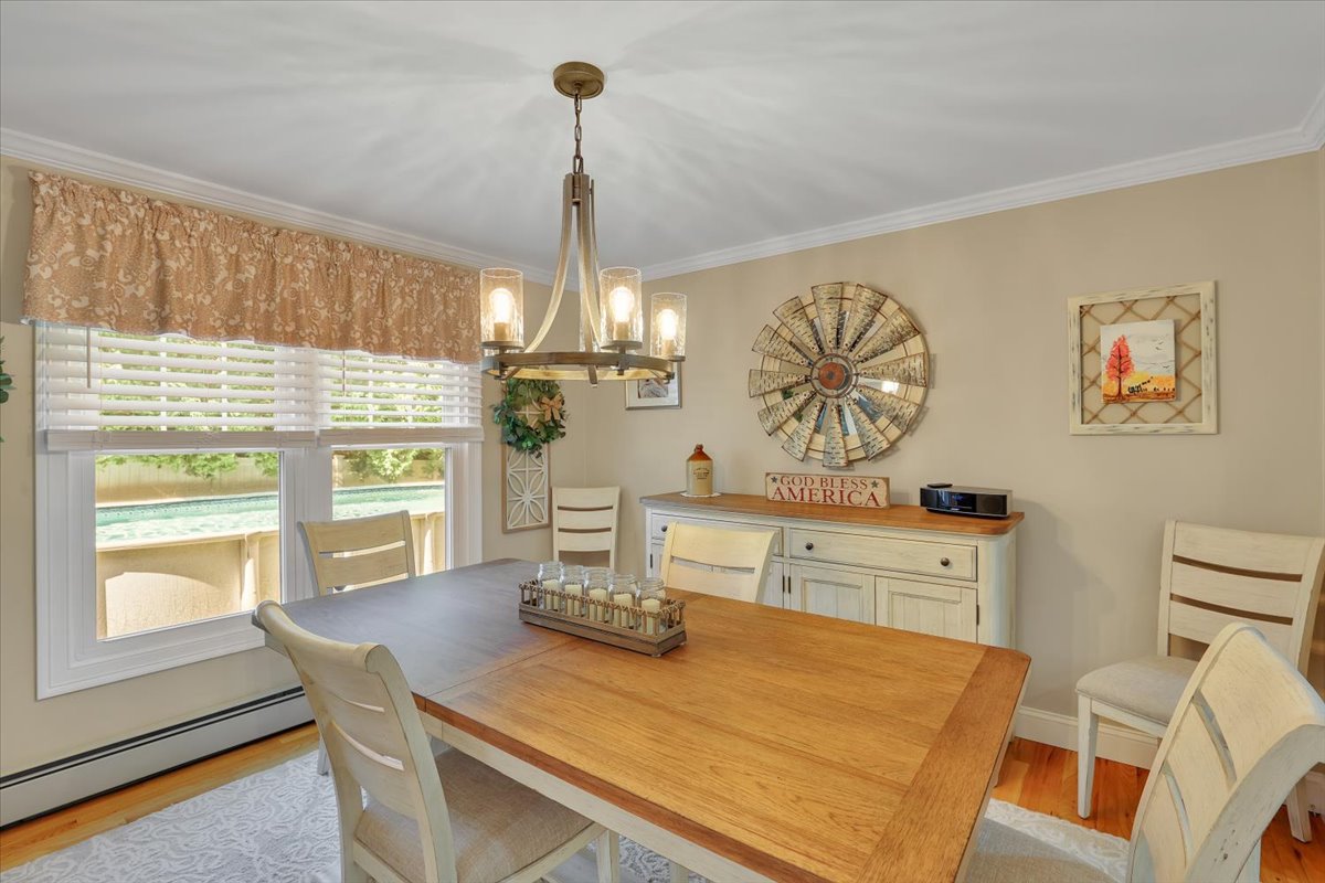 Formal dining room with hardwood floors and a view of the private in-ground swimming pool.
