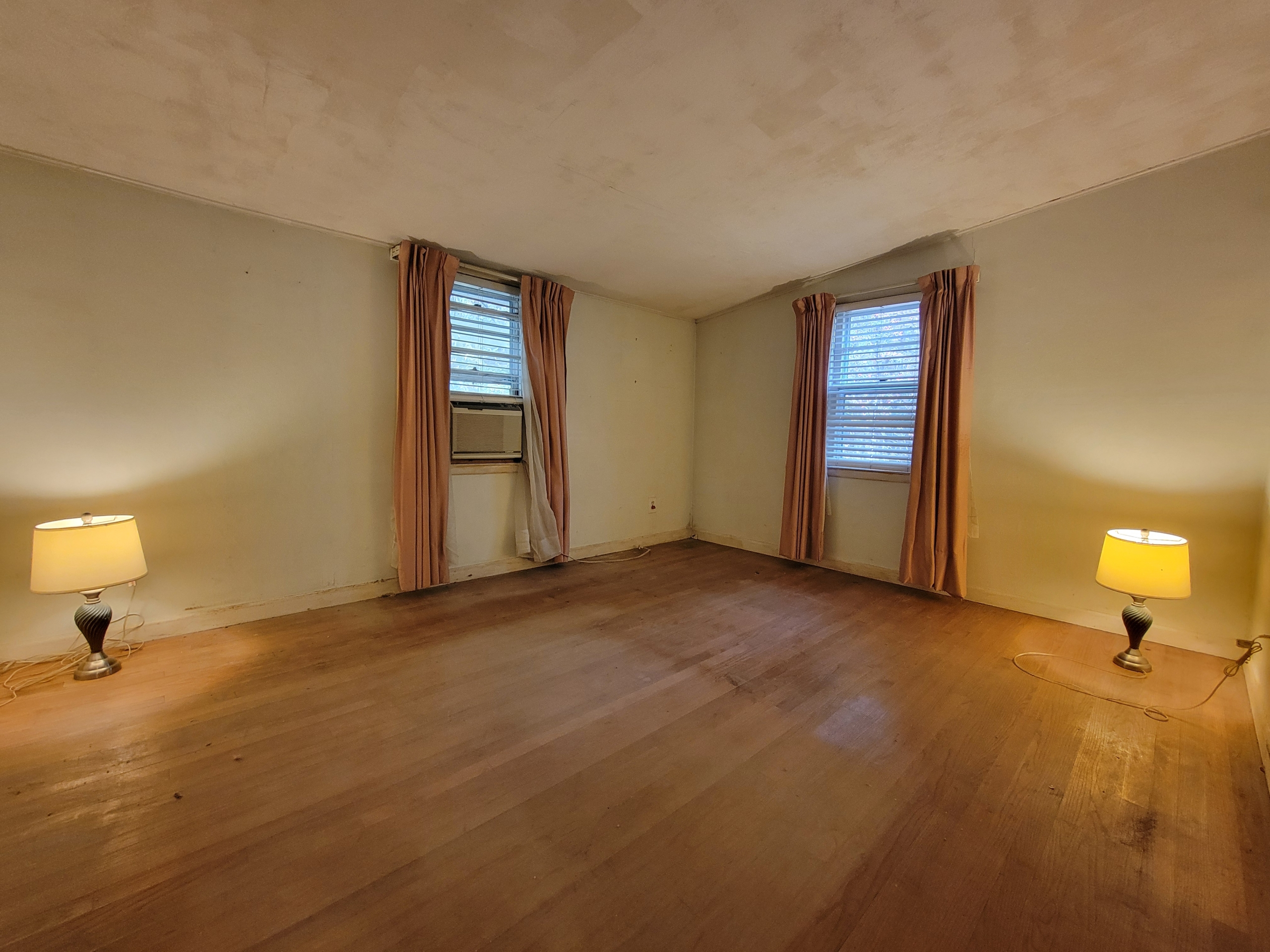 Spacious living room at 60 Chestnut Lane featuring original hardwood floors and large windows for natural light.