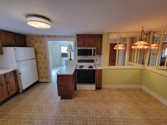 Eat-in kitchen at 60 Chestnut Lane with white refrigerator, electric range, and microwave.