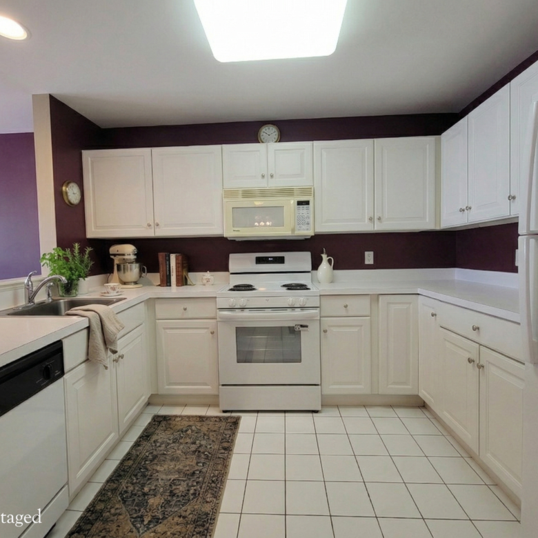A kitchen featuring white cabinetry, white appliances including a new range, and a deep purple accent wall.