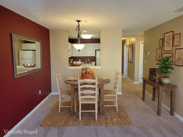 Virtually staged dining area featuring a deep red accent wall with a large mirror, a wooden dining set, and a gallery wall.
