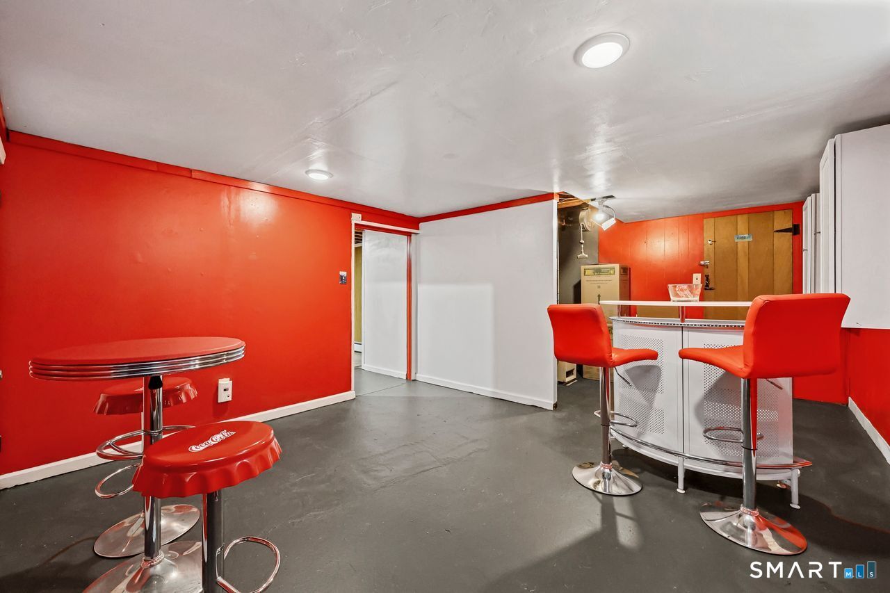 Finished lower-level recreation room with red walls and a retro bar.