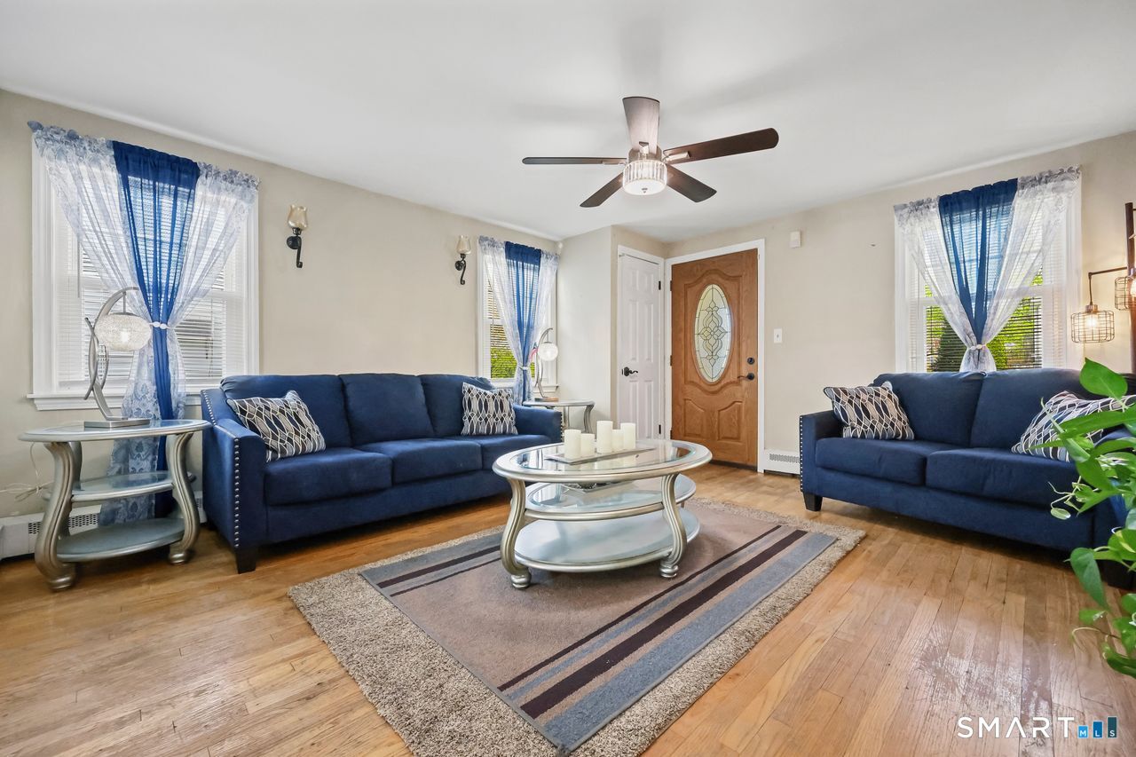 Spacious living room featuring a cozy fireplace and hardwood floors.