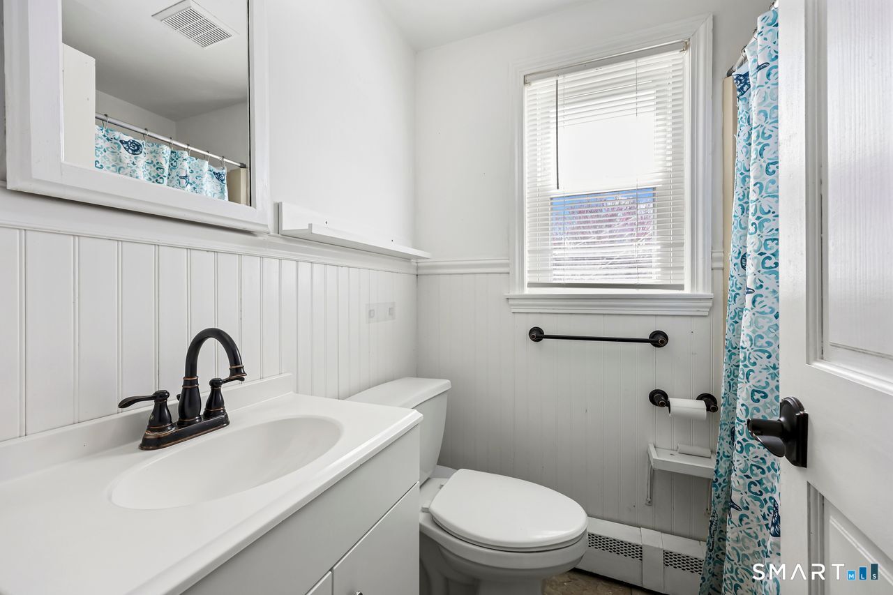 Clean, modern full bathroom with beadboard walls and updated fixtures.