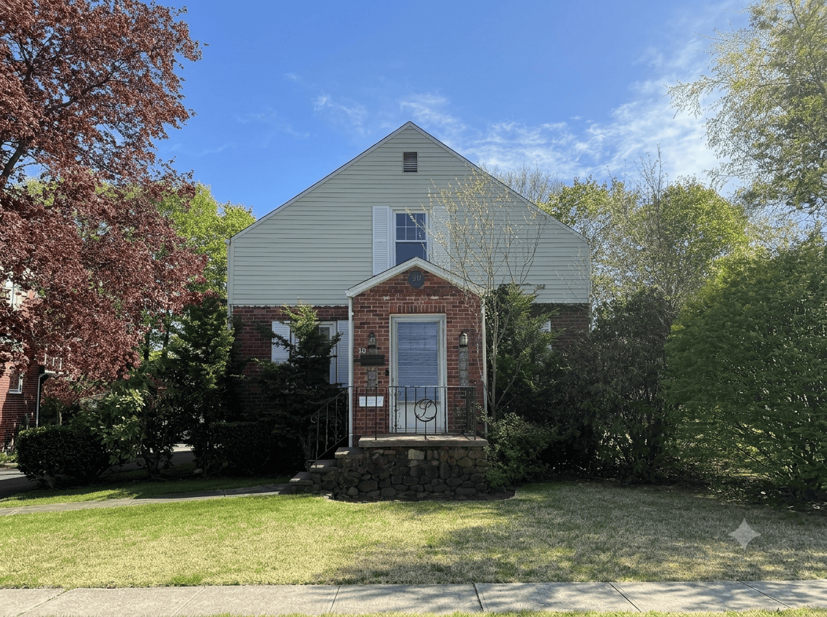 A ranch house in Meriden, CT, featuring mixed beige siding and brick facade, with prominent red and green mature landscaping and a well-maintained lawn.