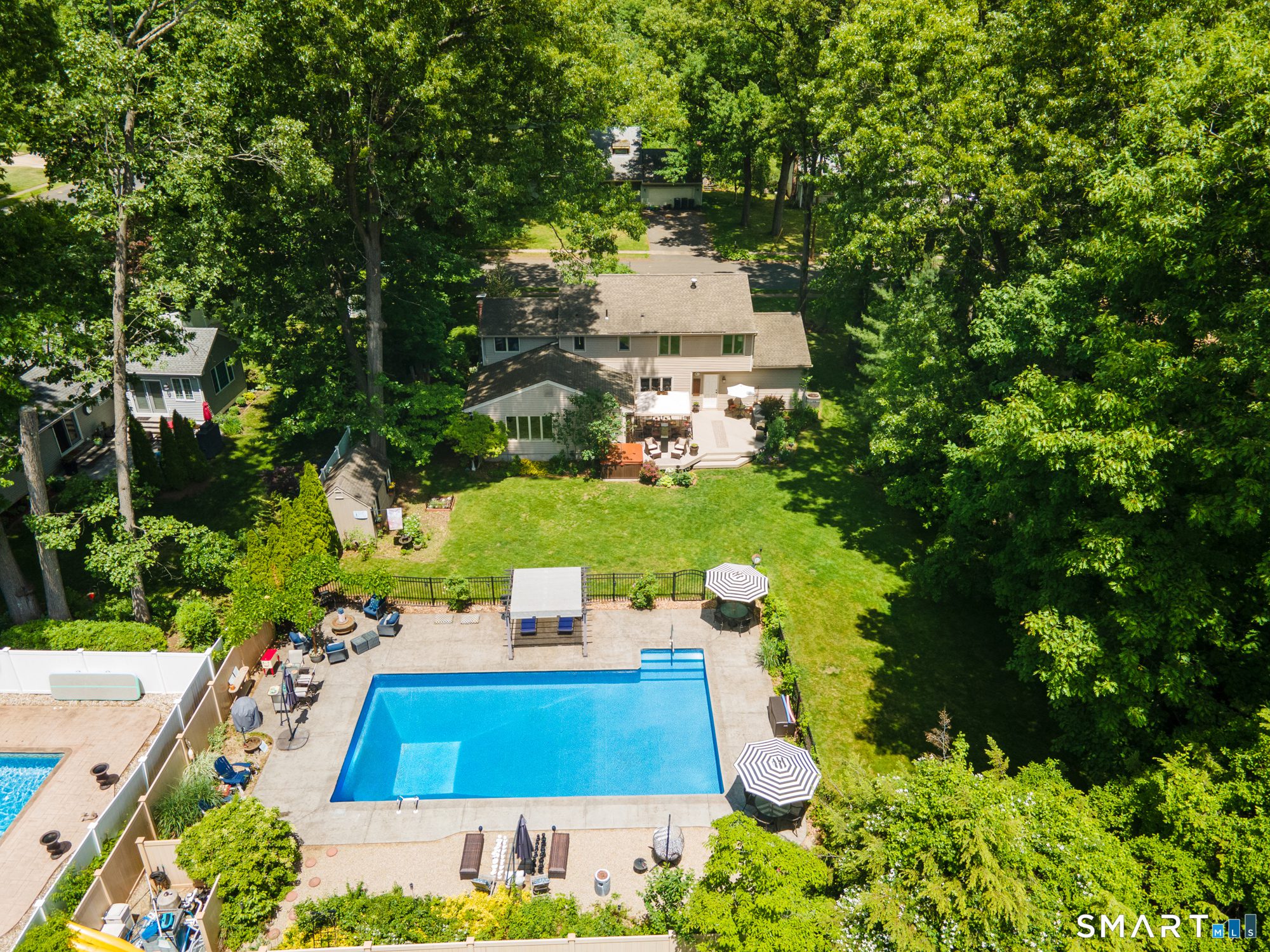 aerial-view-residential-property-cheshire-ct Aerial drone photography of a single-family home in Cheshire, CT, displaying the full property layout, pool, and wooded lot.