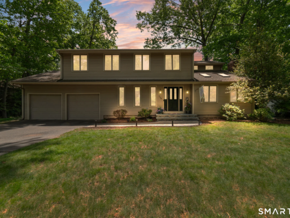 Front exterior view of a beautiful single-family home in Southington, CT, showcasing manicured landscaping and a two-car garage.