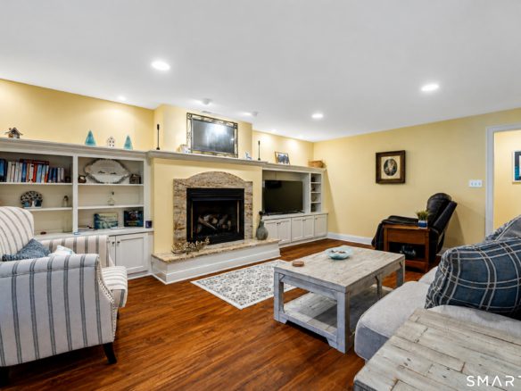 Finished lower level at 10 Crestview Drive with fireplace, built-in shelving and hardwood-style flooring