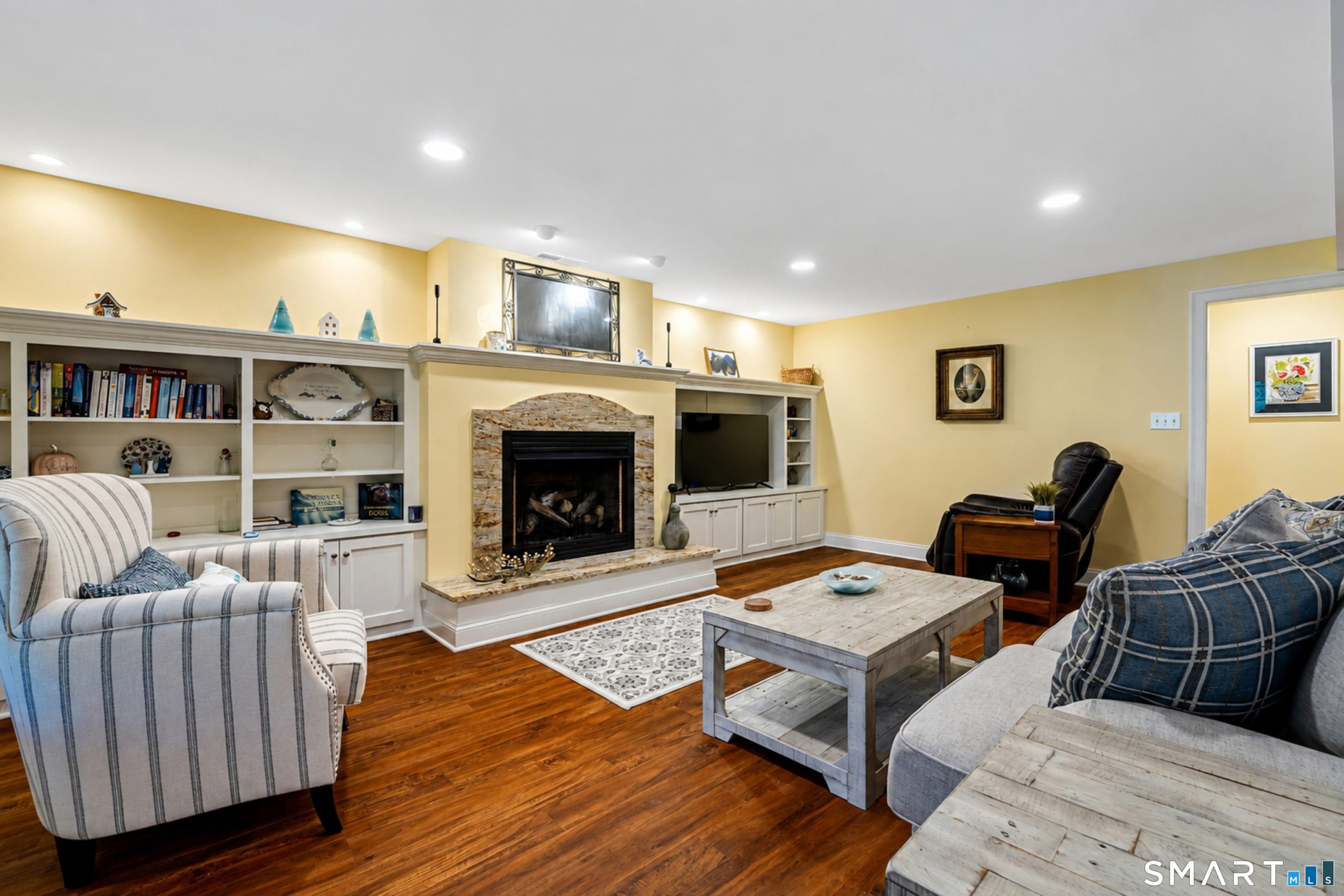 Finished lower level at 10 Crestview Drive with fireplace, built-in shelving and hardwood-style flooring
