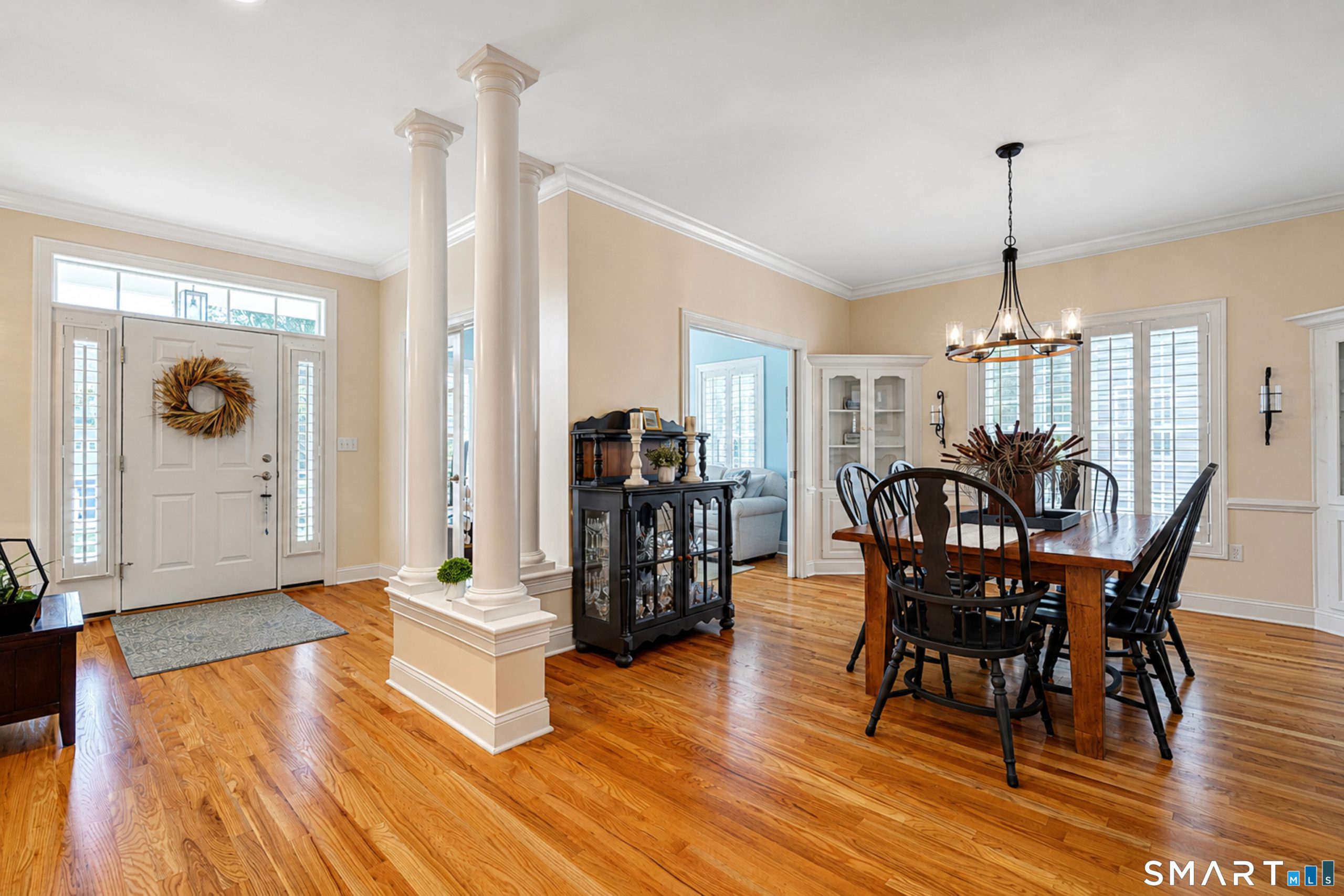 Foyer and dining room at 10 Crestview Drive with hardwood floors, columns and plantation shutters