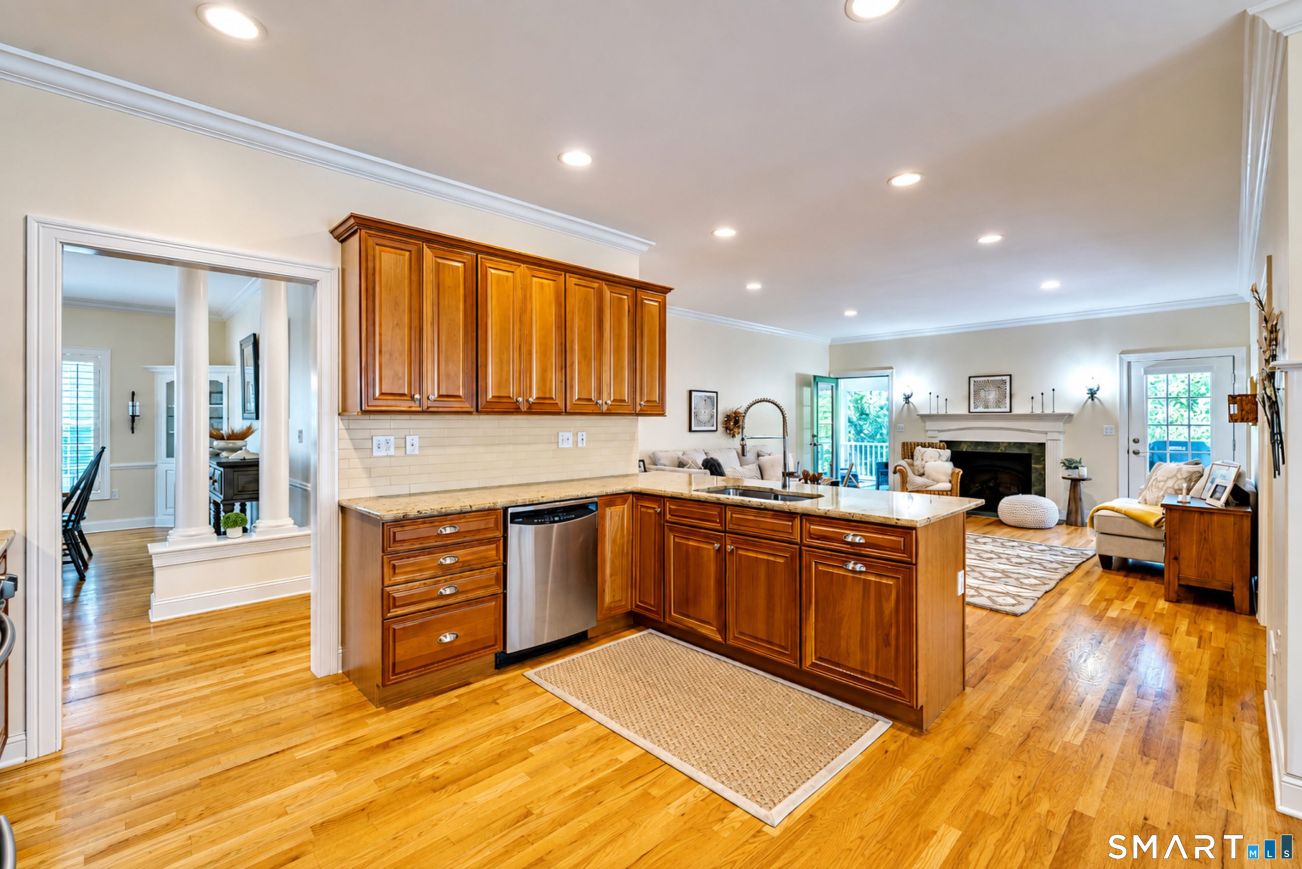 Open kitchen and living area at 10 Crestview Drive with wood cabinetry, granite counters and hardwood floors