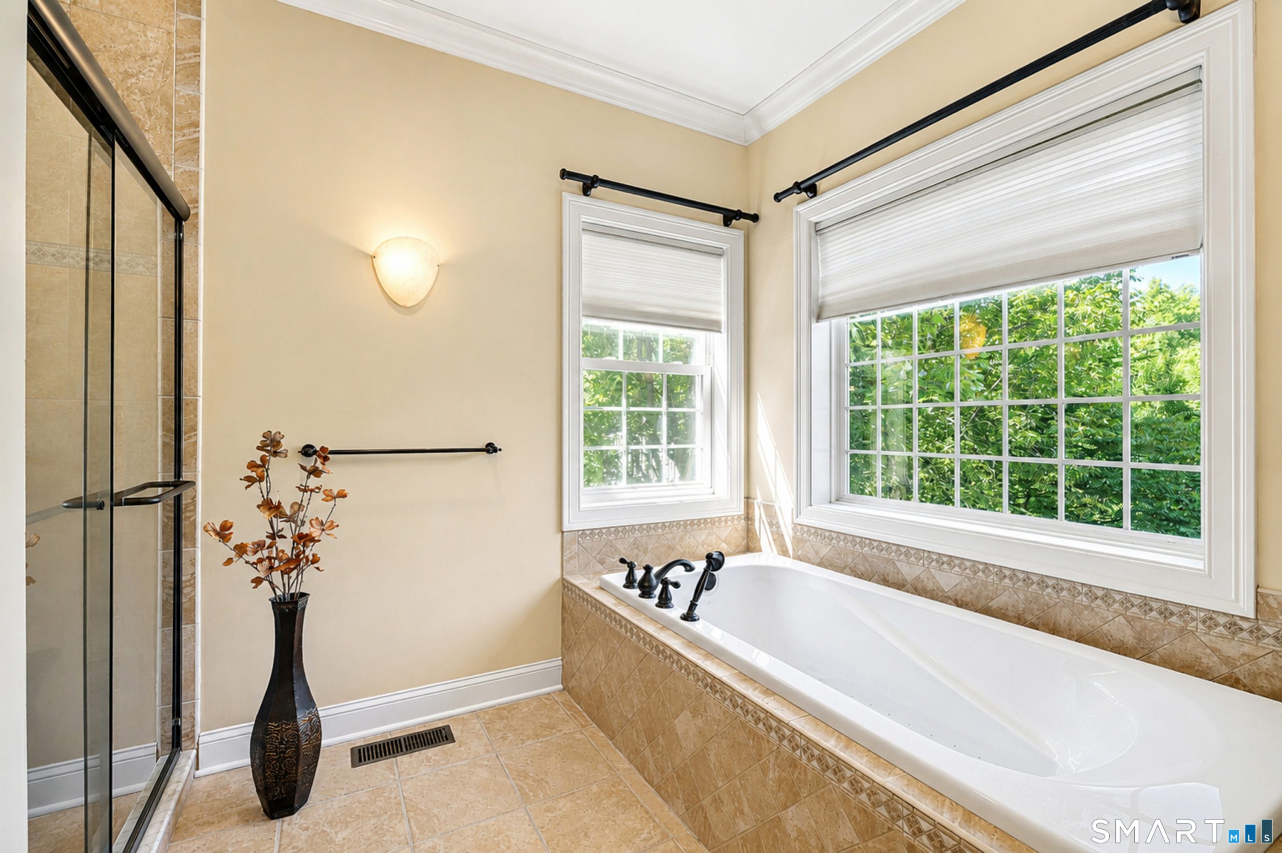 Primary bathroom at 10 Crestview Drive with soaking tub, tiled shower and large windows