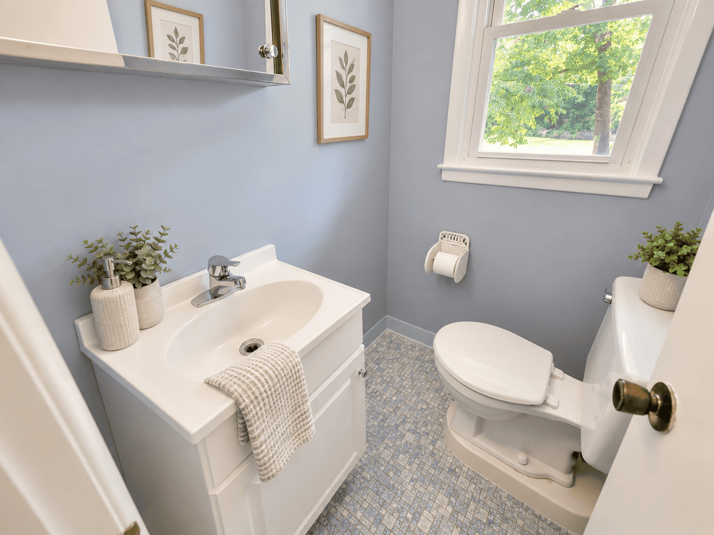 Half bathroom at 488 Radmere Road in Cheshire CT with white vanity, blue walls and natural light.